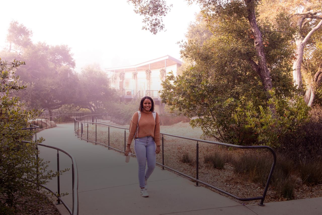 female student walking on campus in morning fog