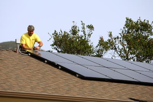 A worker installs a solar panel