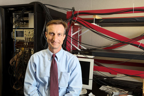 Physics Professor Warren Rogers posing with the new equipment to study supernova explosions