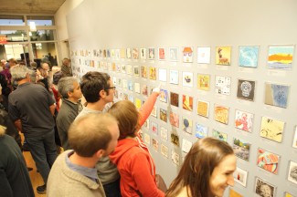 A crowd surveys the artwork during "5X5: An Invitational"