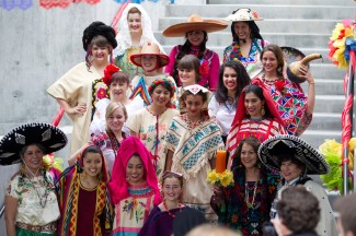 Students and community members model brightly colored Mexican outfits