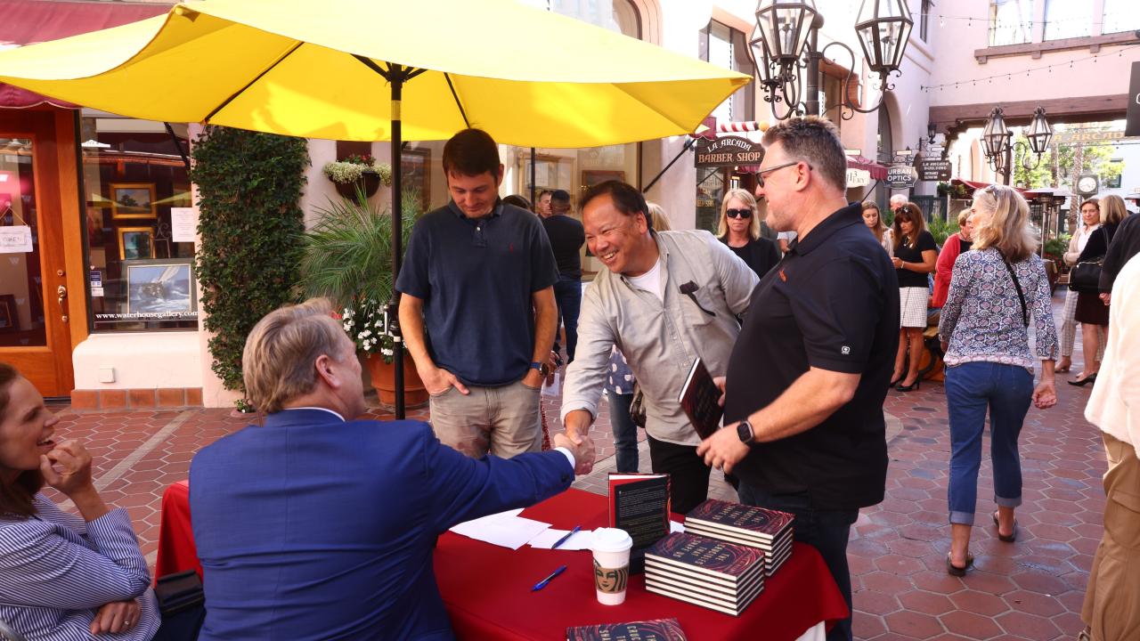 president beebe shaking hands with book signing guests