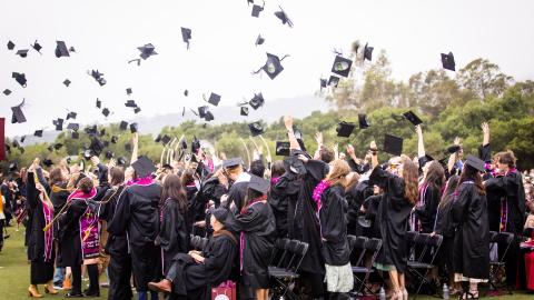 westmont Commencement 2025 students throwing caps in the air