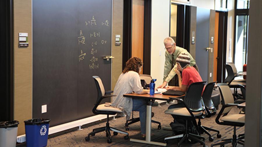 Math professor helping two students in office hours