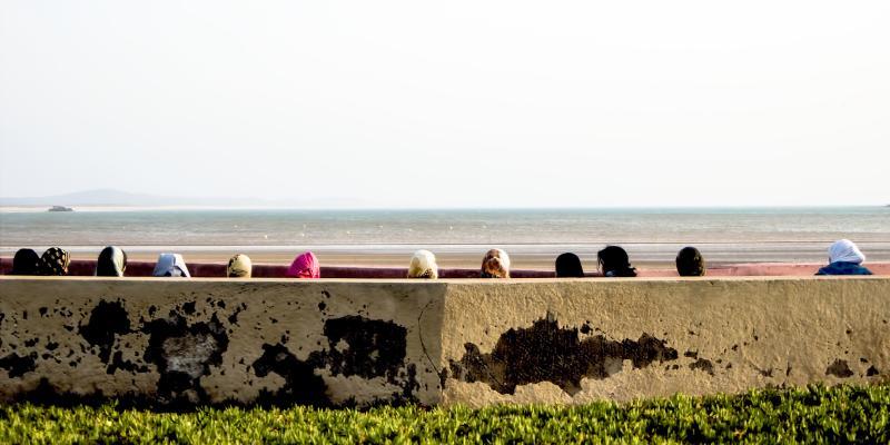 tops of women's heads in scarves looking out to ocean