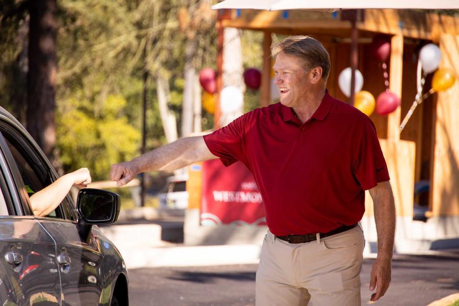 President Gayle D. Beebe offers a fist bump to new students as they arrive for Orientation.