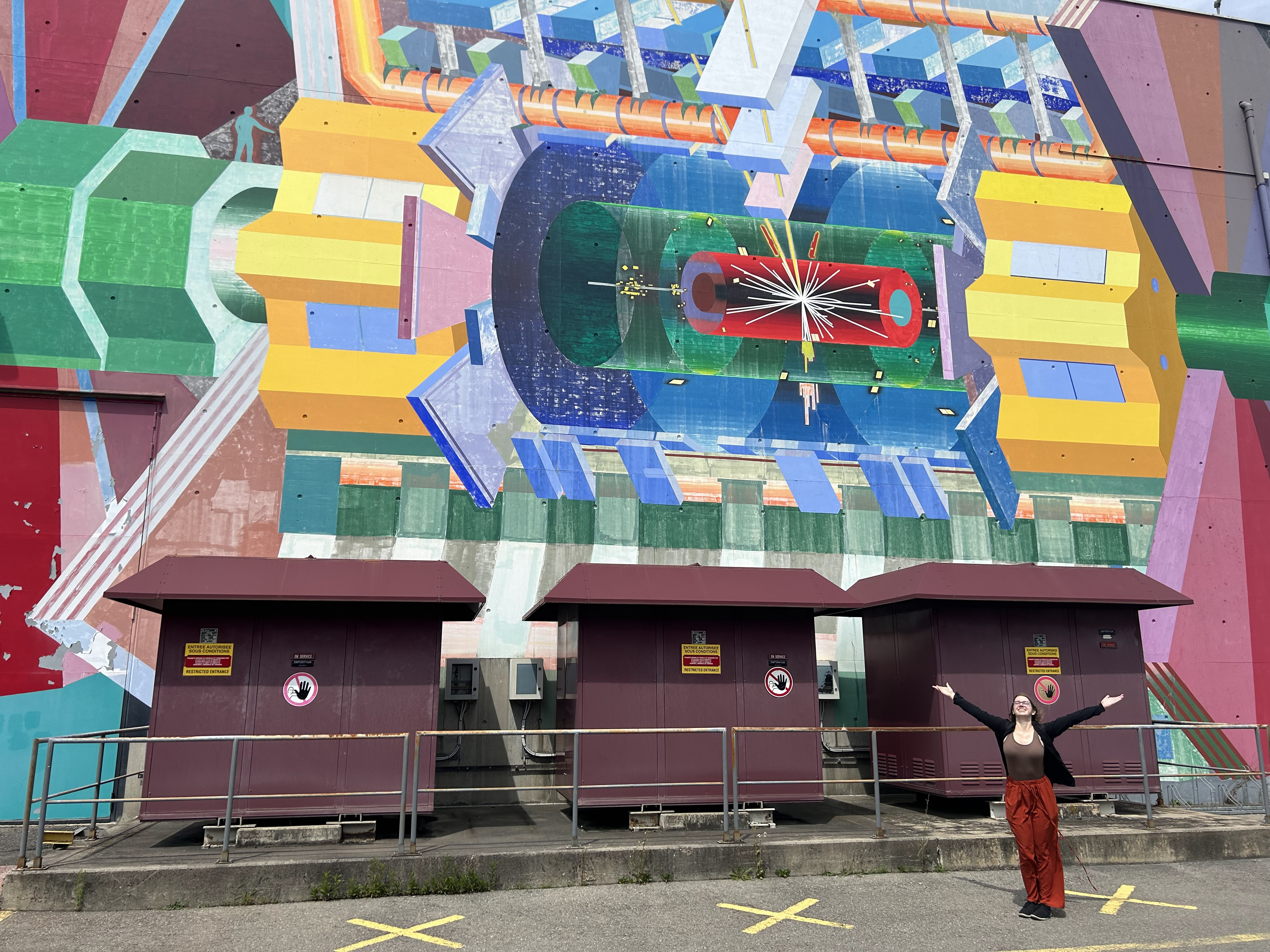 Berit Lunstad in front of a mural of the ATLAS detector at CERN. 